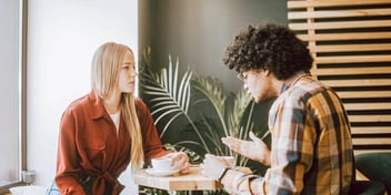 man and woman at a cafe talking