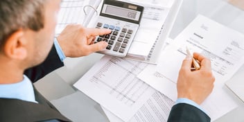 man working on financial paperwork