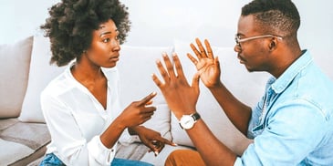 couple arguing while seated on a couch