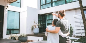 embracing couple standing outside their house