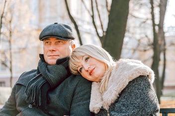dreamy woman resting head on man's shoulder in a winter park