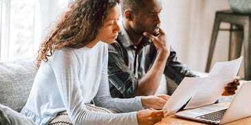 man and woman reviewing financial documents and statements together