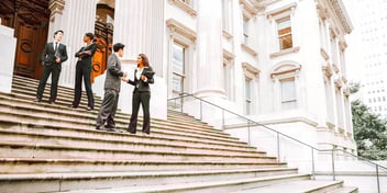 lawyer and client talking on steps outside courthouse