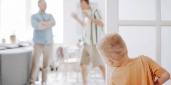 child hiding and listening to his dad and older sibling argue
