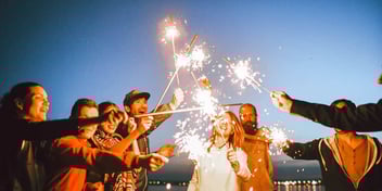 family celebrating the new year with sparklers on a beach