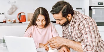 father helping his daughter with her homework