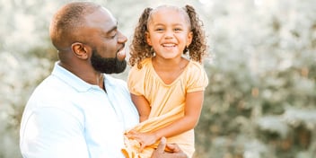 father holding his daughter outside