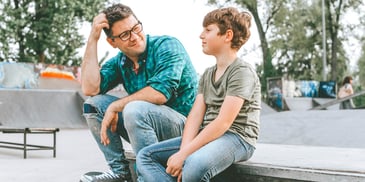 father and son talking in a park