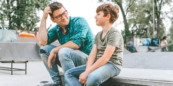 father and son talking in a park