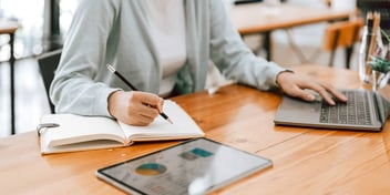 person working on their finances on a laptop notebook and tablet