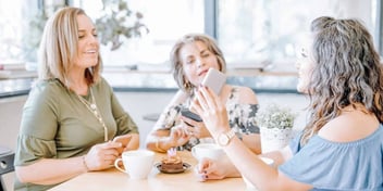 group of women looking at something on a phone