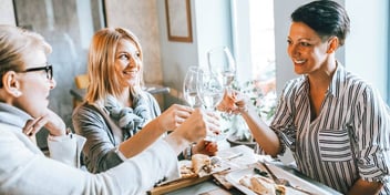 girlfriends toasting divorce with wine at a beach party