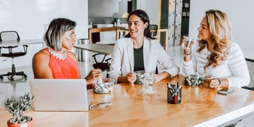 group of girlfriends talking over lunch in one of their kitchens