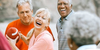 group of adult friends throwing around a football