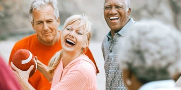 group of adult friends throwing around a football