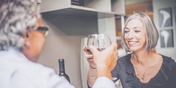older couple toast their happy divorce with a glass of wine