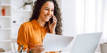woman smiling as she resolves her issues on the phone