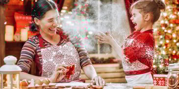 mother and daughter baking holiday cookies together