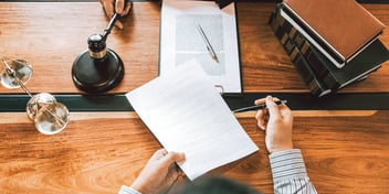 desk in a legal office with people filling out paperwork
