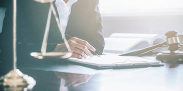 person filling out paperwork in a legal setting