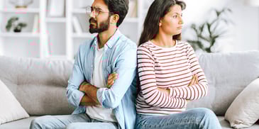 couple sitting facing away from each other arms folded