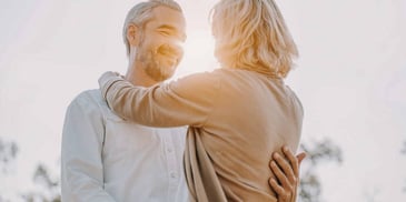 Man and woman hug during sunset