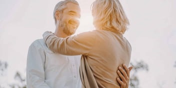 Man and woman hug during sunset