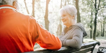 Man and woman relax and talk on a park bench