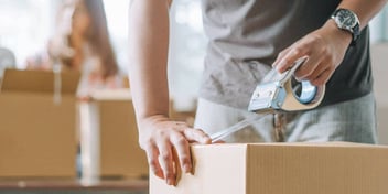 person packing moving boxes while their ex watches 