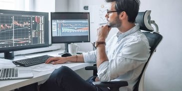 man checking stocks and his financial reports online