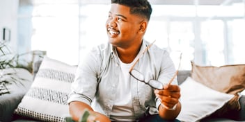man holding glasses and smiling