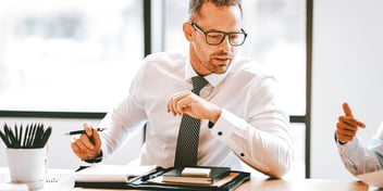 Man in business attire speaking with colleague