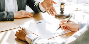 two people meeting with one explaining and the other taking notes