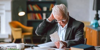 man is stressed out looking over his credit card bills