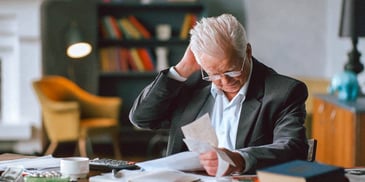 man is stressed out looking over his credit card bills