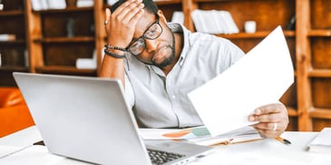 frustrated man working on financial paperwork