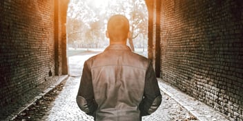 man walking away through a tunnel