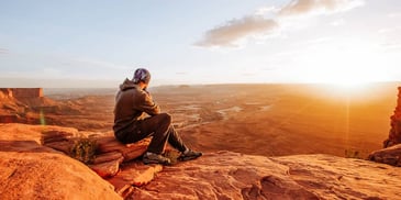 man contemplates life after divorce with hope as he watches the sun rise over mountains