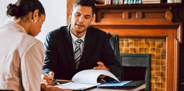 man and woman meeting and going over paperwork in a law office