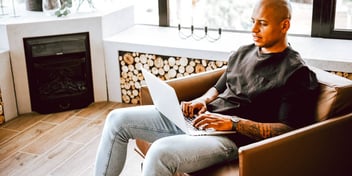 Man working on his laptop while sitting on an armchair