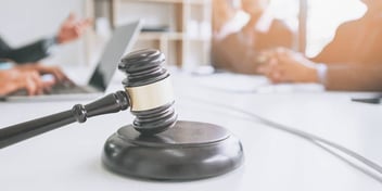 group of people in a legal setting meeting at a table with gavel