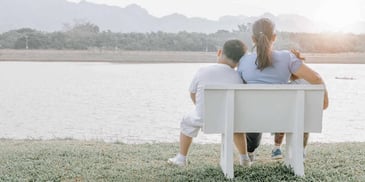 mother sitting with her two kids on a bench along the waterfront