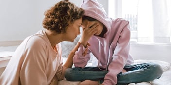 mom comforting sad daughter