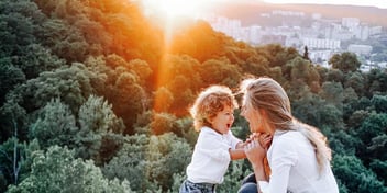 kid and mom in trees above city