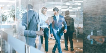 people walking and talking in an office