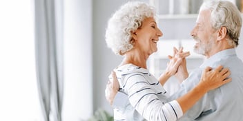 Man and woman dance together in living room