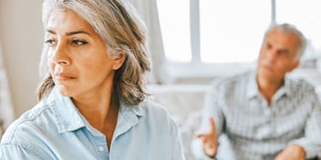 Older woman ignoring older male partner while he is trying to speak to her.