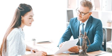 lawyer and client meeting in an office going over paperwork