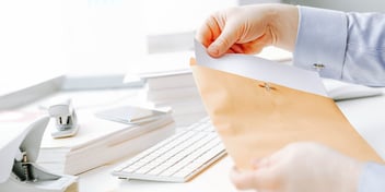 person holding divorce papers in a manila envelope