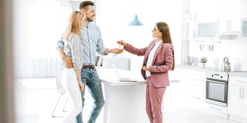 real estate agent handing a couple keys to their new house
